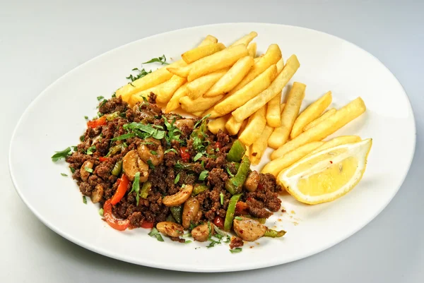 Prato de batatas fritas árabes com carne assada e limão . — Fotografia de Stock