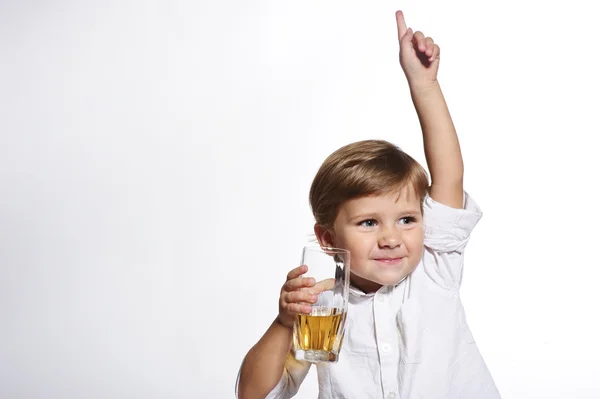 Pequeño niño lindo con vaso de jugo de manzana en fondo blanco — Foto de Stock