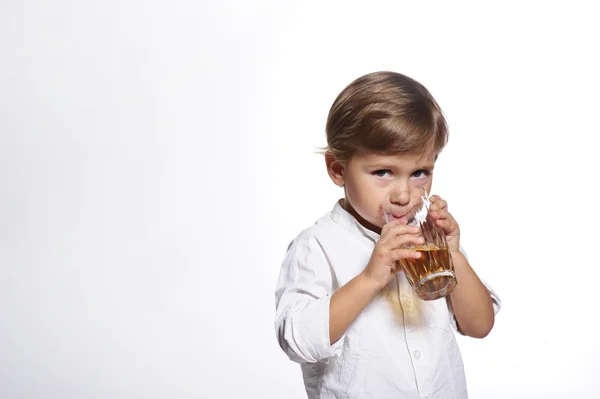 Liten söt pojke med glas äppeljuice i vit bakgrund — Stockfoto