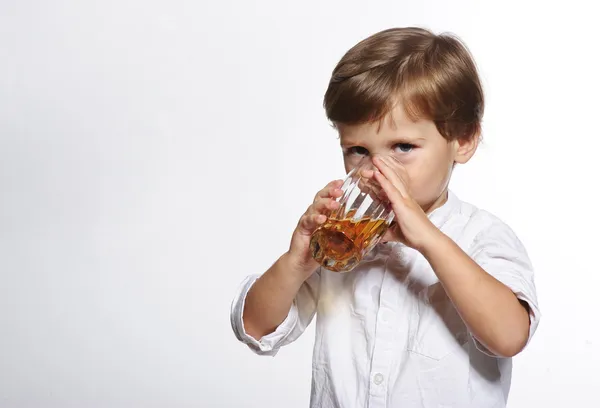 Kleiner netter Junge mit einem Glas Apfelsaft auf weißem Hintergrund — Stockfoto