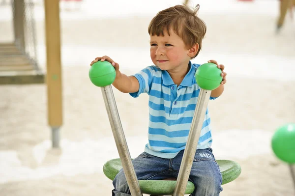 Pequeno menino bonito se divertindo no parque infantil site — Fotografia de Stock