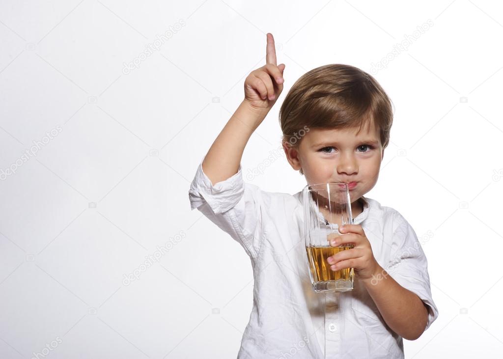 Little cute boy with glass of apple juice in white background