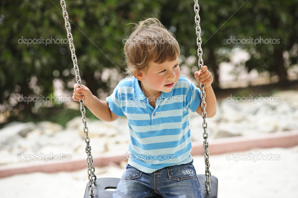 Little cute boy having fun on chain swings