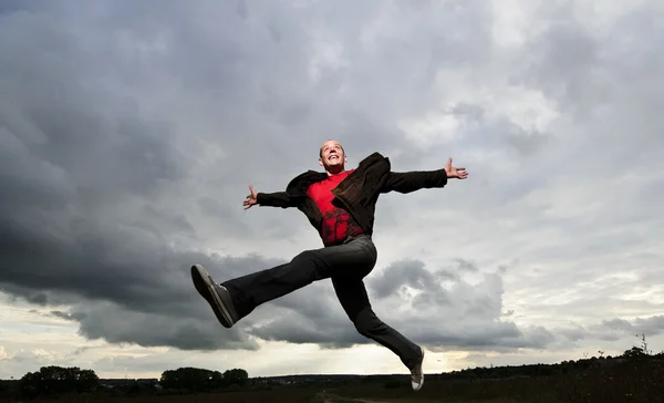 Jang člověka je skákat vysoké před dramatické nebe — Stock fotografie