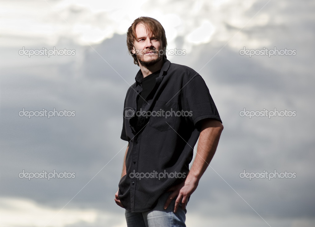 Yang man stands in front of sunset dramatic sky background