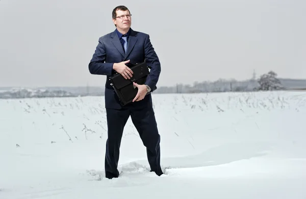 Yang homem de negócios vestido de terno parece perdido no deserto de neve . — Fotografia de Stock