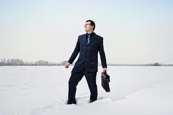 Yang biznesmen ubrany w garnitur wygląda stracił w śniegu pustyni. — Zdjęcie stockowe