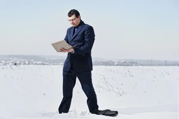 Yang affärsman klädd i kostym ser förlorade i snö öknen — Stockfoto