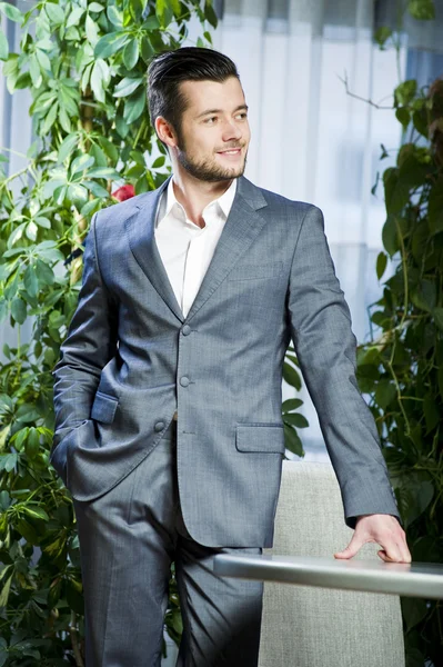 Portrait of yang and confident man in grey business suit. — Stock Photo, Image