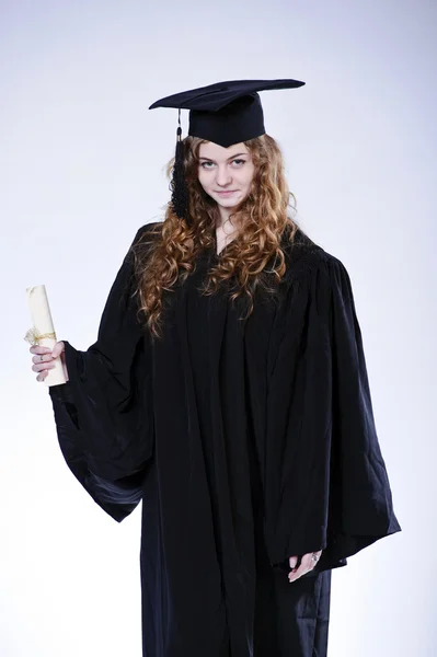 Estúdio retrato de belo encaracolado estudante graduando feminino vestido de copo e vestido — Fotografia de Stock