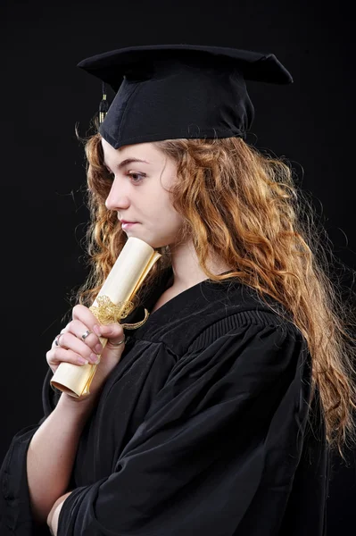 Retrato de estudio de una hermosa estudiante graduada rizada vestida con copa y vestido — Foto de Stock