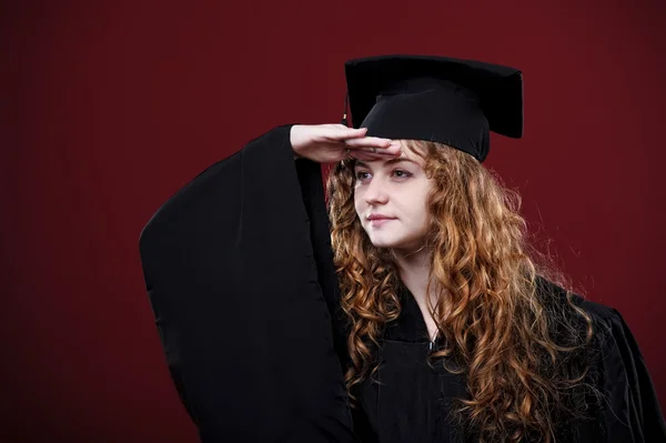 Retrato de estudio de una hermosa estudiante graduada rizada vestida con copa y vestido — Foto de Stock