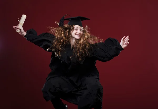 Estúdio retrato de belo encaracolado estudante graduando feminino vestido de copo e vestido — Fotografia de Stock