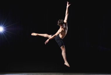Modern style erkek balet yüksek ışıklı sahnede performans sergiliyor.
