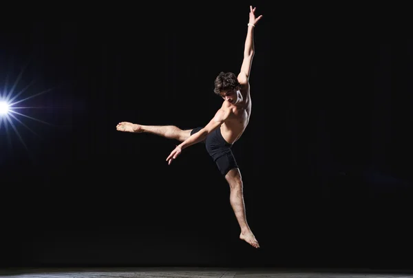 Modern ballet style male dancer performs on high lighted stage — Stock Photo, Image