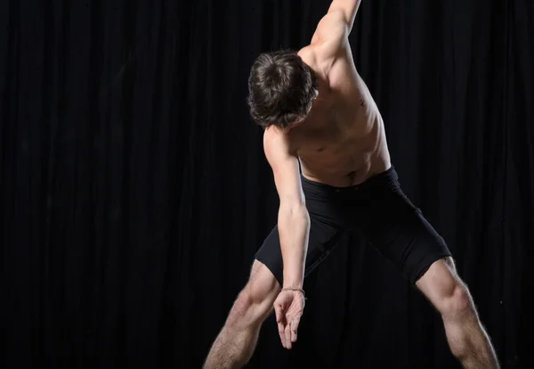 Bailarín masculino de estilo ballet moderno actúa en el escenario iluminado —  Fotos de Stock