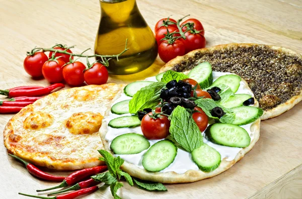 Piatto tradizionale orientale di manaqish, topper di pane piatto con formaggio e ingredienti diversi — Foto Stock