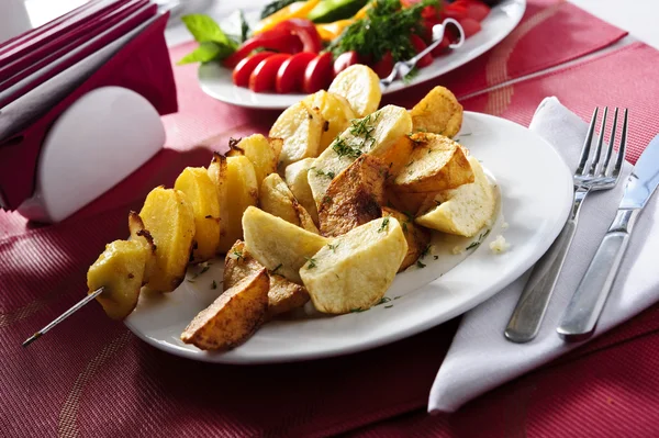 Plaat van gebakken aardappelen gekookt op een spies — Stockfoto