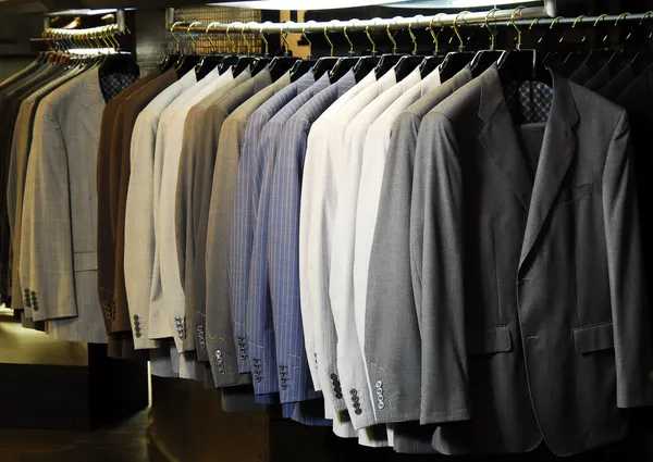 Сырые разноцветные мужские куртки висят на одежде. — стоковое фото