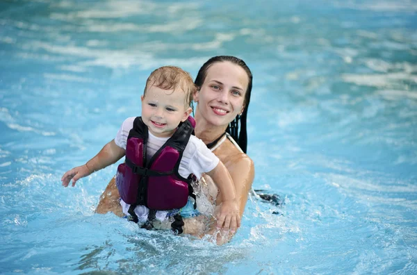 Yang e bella madre insegnano al suo bambino come nuotare — Foto Stock