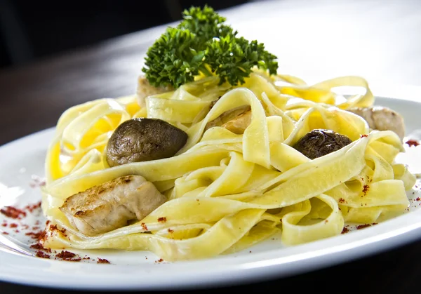 Plate of traditional Italian pasta topped with mushrooms and chicken — Stock Photo, Image