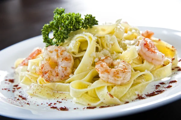 Prato de macarrão tradicional italiano coberto com comida do mar — Fotografia de Stock