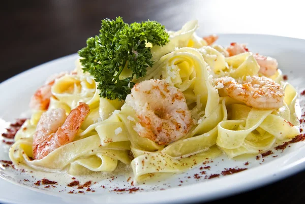 Prato de macarrão tradicional italiano coberto com comida do mar — Fotografia de Stock