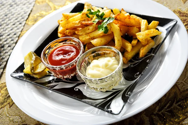 Placa de papas fritas con salsas blancas y rojas — Foto de Stock