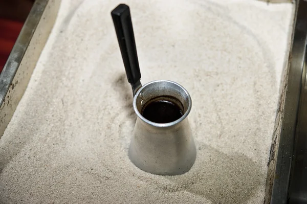 Picture of traditional Eastern coffee pot and sand box for its preparation