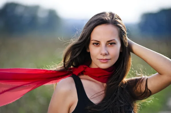 Outdoor portrait of yang beautiful woman with red scarf — Stock Photo, Image