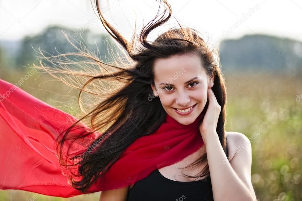 Outdoor portrait of yang beautiful woman with red scarf