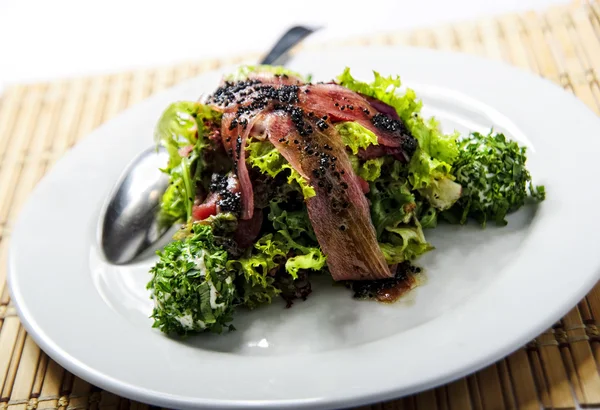 Plaat van geen gewone salade gegarneerd met zwarte kaviaar — Stockfoto