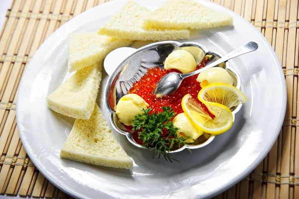 Tigela de caviar vermelho, coberto com bolas de manteiga de limão e endro — Fotografia de Stock