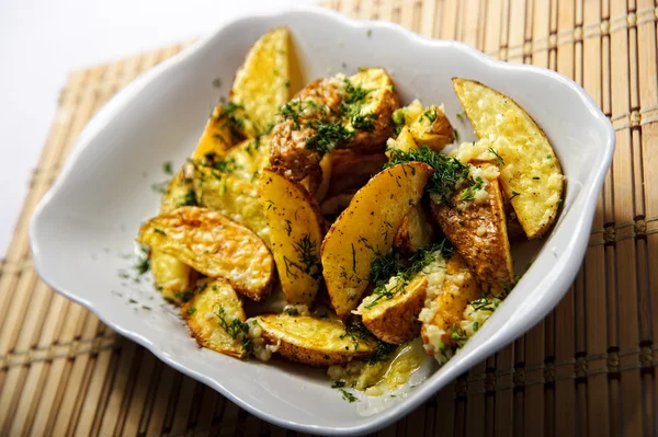 Stukken van gebakken aardappelen gegarneerd met gesneden dill — Stockfoto