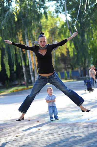 Yang and beautiful mom playing outdoor with her small son