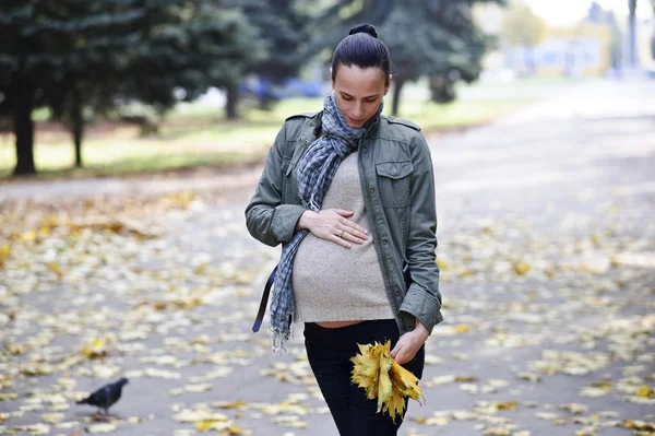 Jang a roztomilý těhotná žena chodí sám na podzimní pozadí — Stock fotografie
