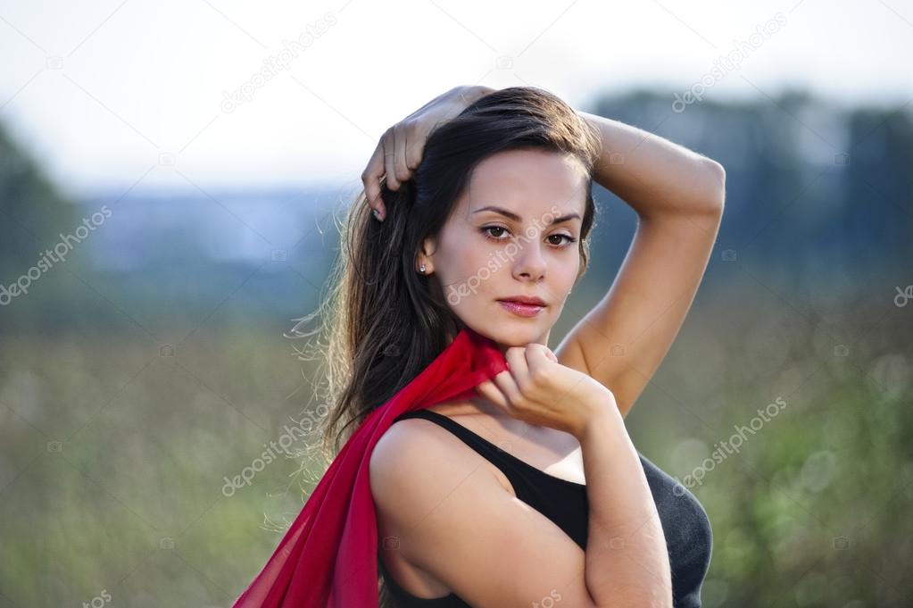 Outdoor portrait of yang beautiful woman with red scarf.
