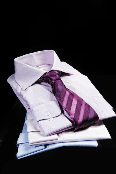 Close up of stacked shirts with tie — Stock Photo, Image