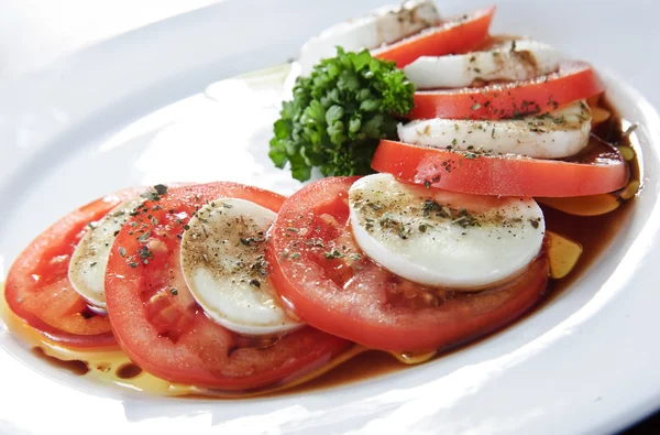 スライスしたトマトと白チーズ、伝統的なイタリアの前菜のプレート — ストック写真