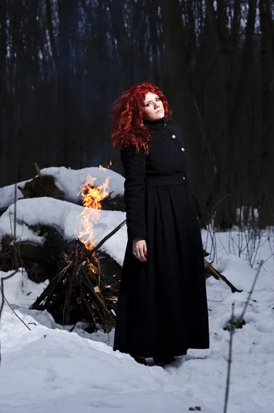 Portret kobiety czerwone włosy piękne i dzikie yang myśliwego w lesie ponure zimowe. — Zdjęcie stockowe
