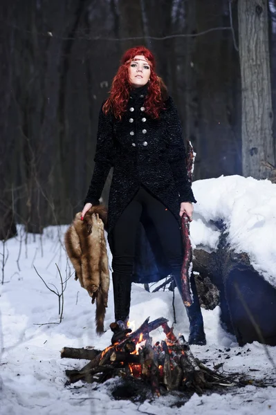 Porträtt av röda haired vackra och vilda yang kvinna jägaren i skogen dystra vintern. — Stockfoto