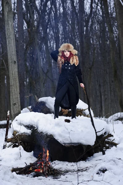 Portrait of red haired beautiful and wild yang woman the hunter in the winter gloomy forest. — Stock Photo, Image