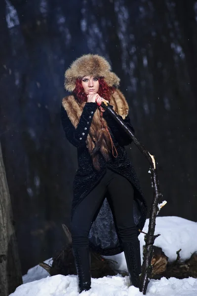 Kızıl saçlı güzel ve vahşi yang kadın avcısı kış kasvetli ormanın içinde portresi. — Stok fotoğraf