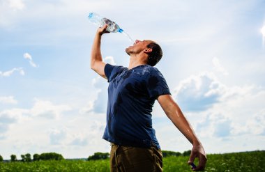 volwassen mam speelt met water onder groen veld