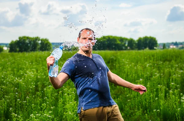 Adulte mère joue avec l'eau parmi le champ vert — Photo