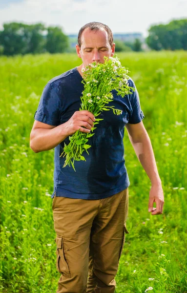 Portret wieśniak z bukiet kwiatów wyróżnia wśród zielonych pól — Zdjęcie stockowe