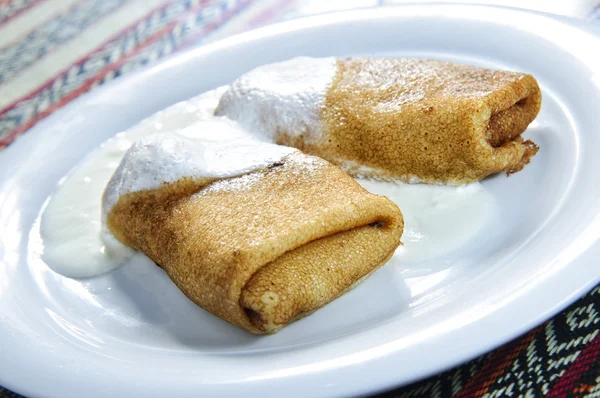 Plate of pancakes topped with cream — Stock Photo, Image