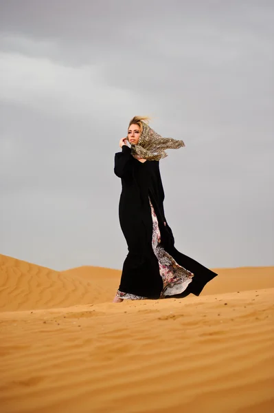 Portrait of arabic way dressed woman in yellow desert — Stock Photo, Image