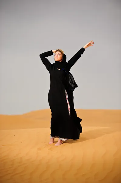 Portrait of arabic way dressed woman in yellow desert — Stock Photo, Image