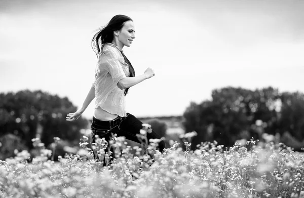 Pretty young European woman jumping on green field — Stock Photo, Image